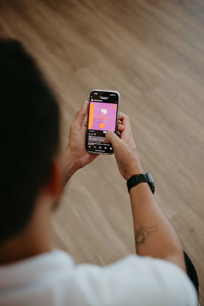 who-we-are An individual using a smartphone indoors, engaging in mobile application interaction.